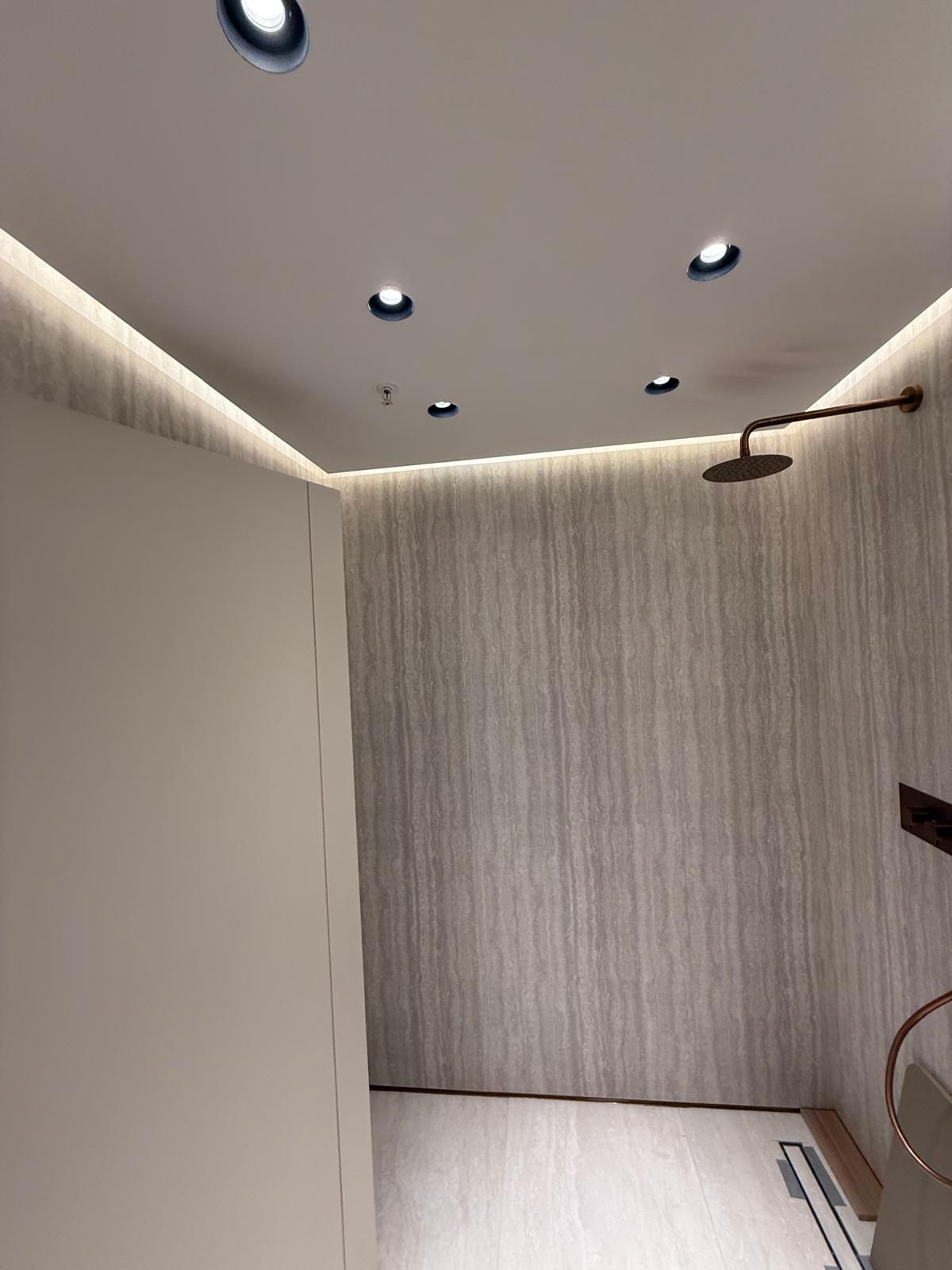 Walk-in shower with a rainfall head and LED cove