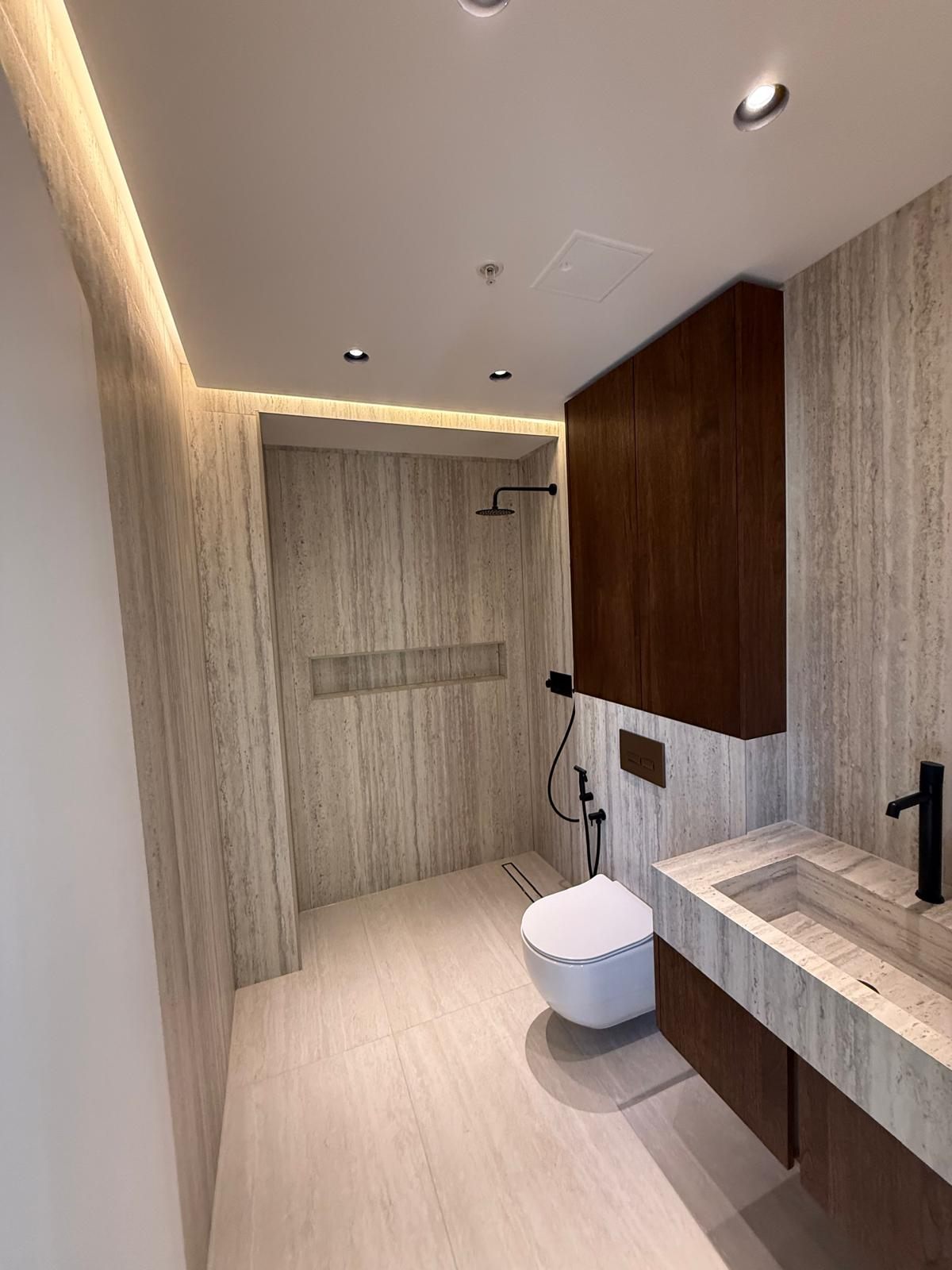Bathroom with a stone vanity, walnut cabinet and walk-in shower