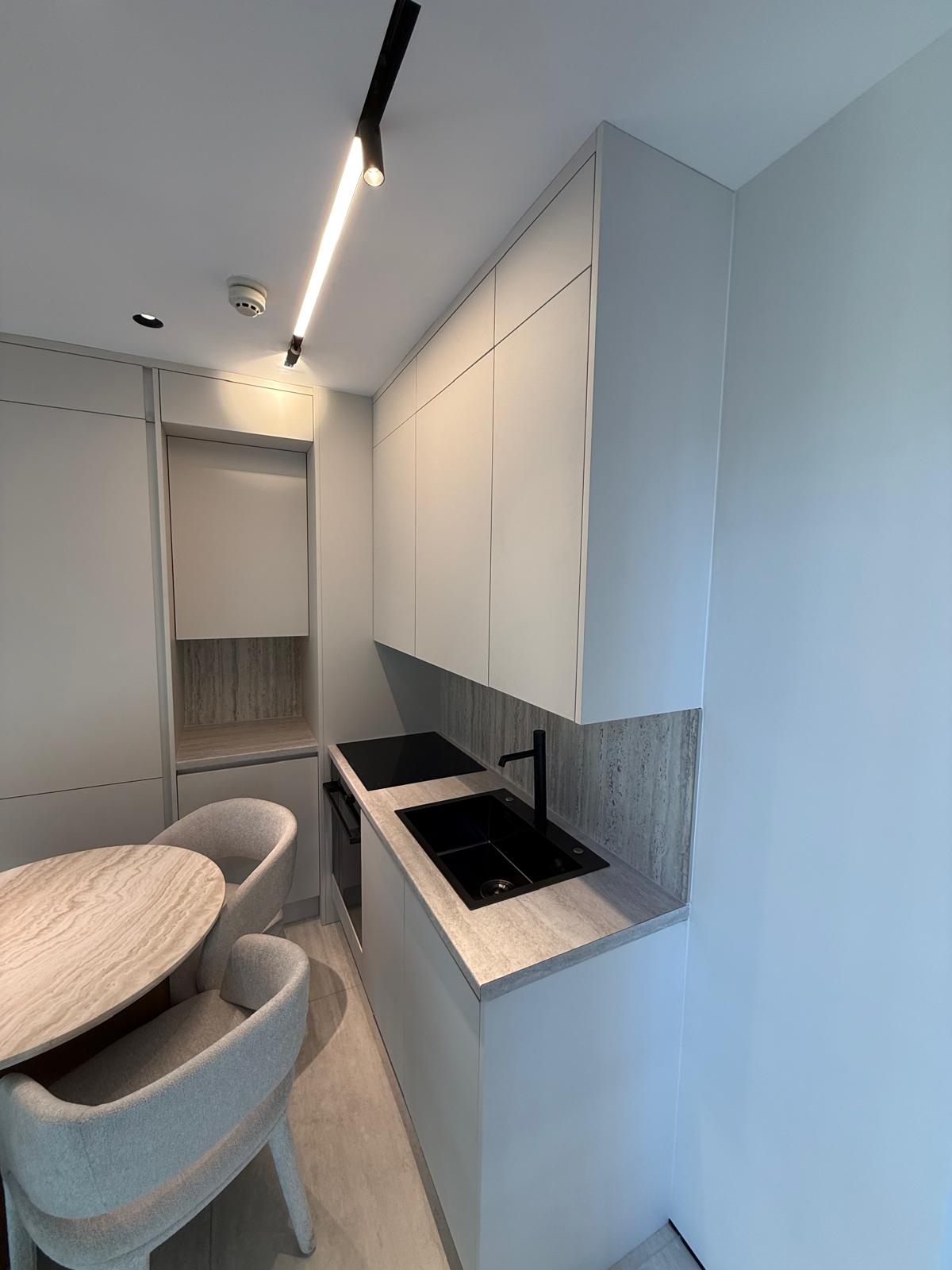 Compact kitchen with a black sink and tall units