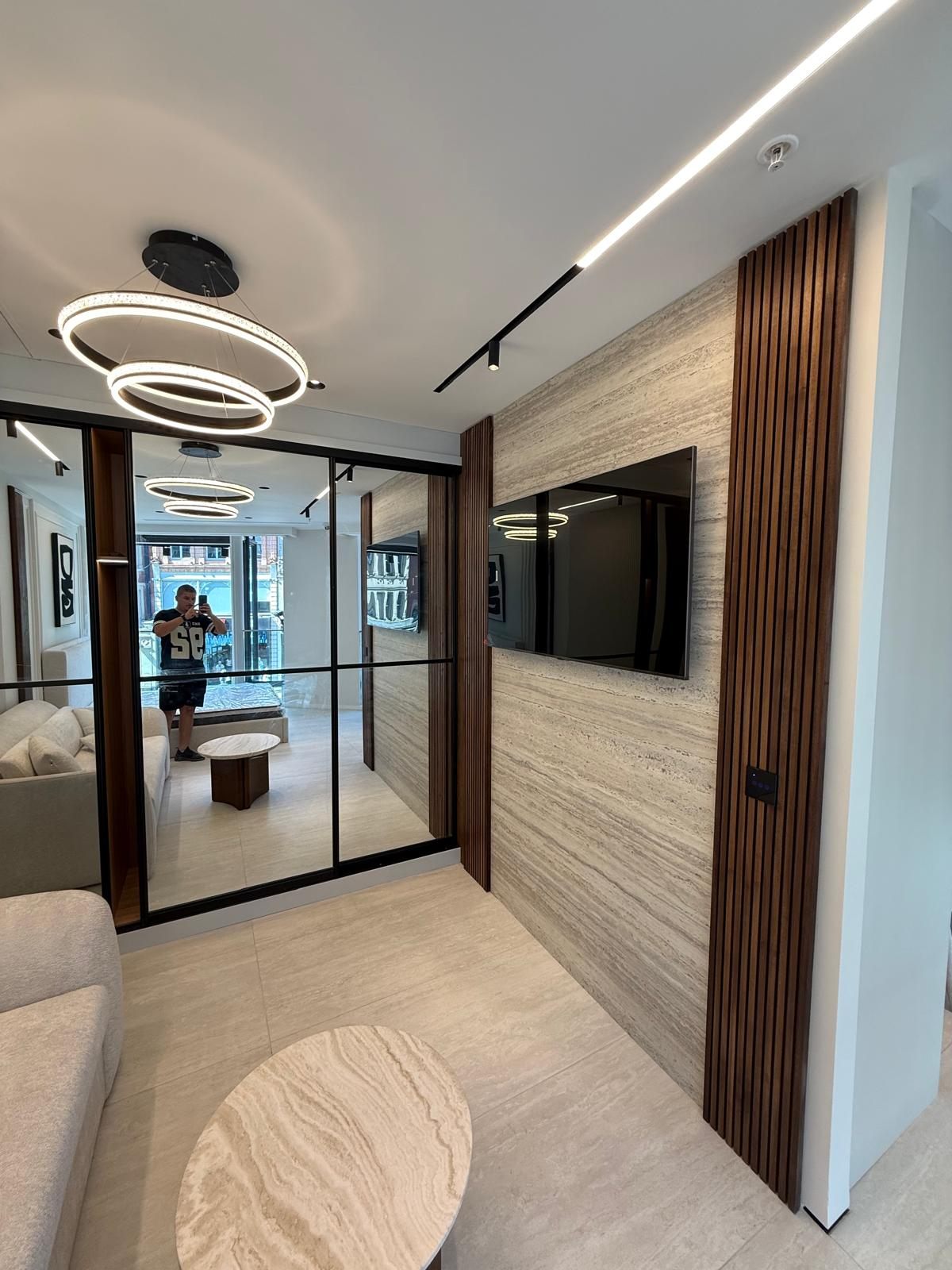 Travertine feature wall, walnut slats and a glazed partition