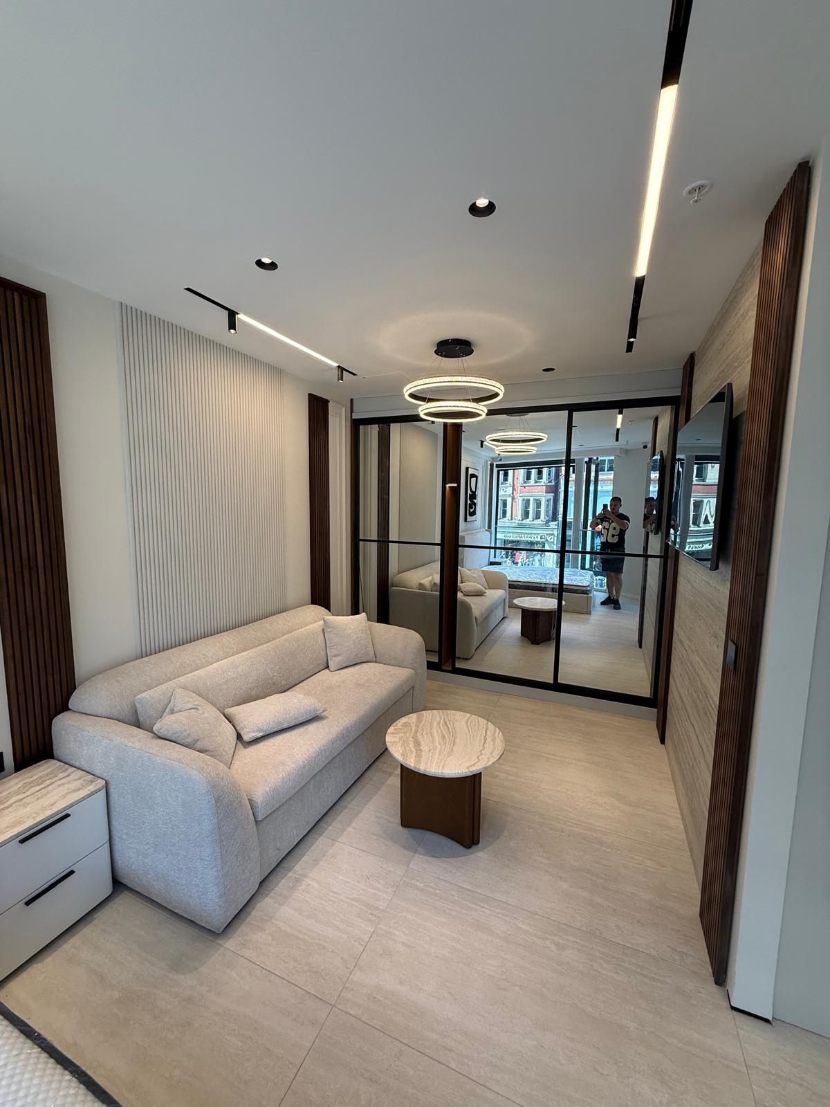 Living room with walnut slat panels and a glazed partition
