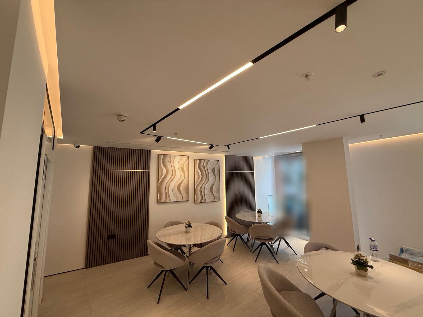 Communal area with warm LED coves and walnut slats